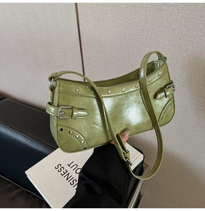 Détail du sac à bandoulière vert brillant avec rivets punk et boucle de réglage latérale