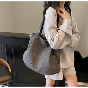 Detail of grey canvas tote bag featuring four unique blue diagonal stitch accents