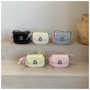 Détail de sacs selle colorés en similicuir avec boucles fer à cheval et breloques perles