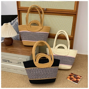 Detail of woven straw tote bags in black, beige and brown colors for beach vacation