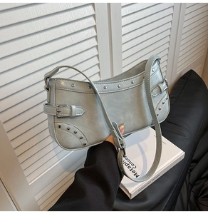 Détail du sac à bandoulière en similicuir bleu clair avec clous et boucles argentés