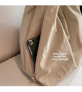 Detail view of a side zipper pocket on canvas tote bag storing a small tablet device