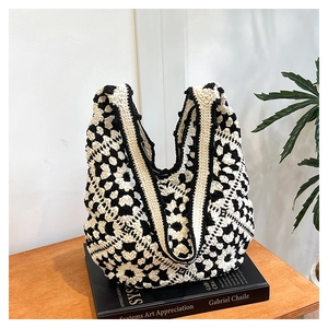 Detail of hand-crocheted tote bag with black and white floral pattern on art book