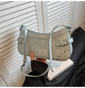 Détail du sac hobo en similicuir bleu clair avec rivets argentés et boucles métalliques