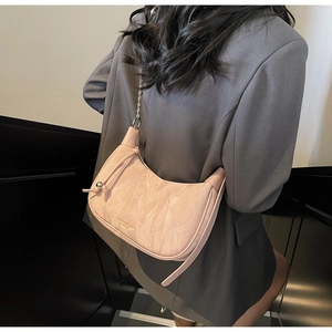 Pink crescent moon bag with crinkled patent leather texture and metal chain strap
