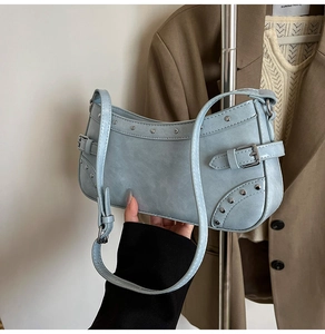 Détails de l'intérieur et extérieur d'un sac sous le bras bleu clair avec rivets métalliques