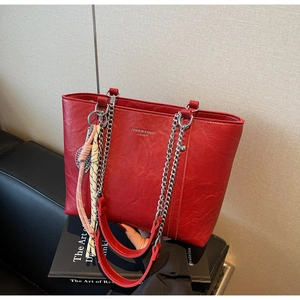 Detail of red large tote bag featuring vintage pleated texture and silver chain strap