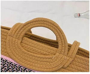 Macro shot of circular woven handles and colorful knit texture on straw tote bag