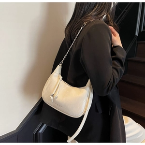 Detail of cream crescent shoulder bag with silver chain and side drawstring decoration