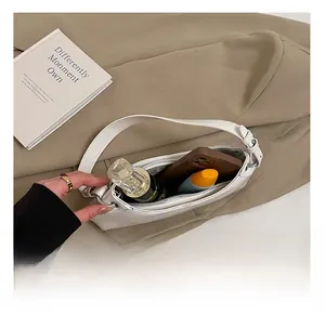 Top view of white leather underarm bag showing interior capacity for phone and cosmetics