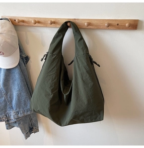 Detail of army green nylon hobo bag featuring drawstring accents and wrinkled texture