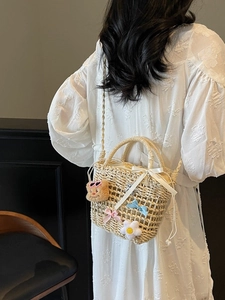 Handwoven straw bucket bag with cute bear and bow charms for summer beach vacations