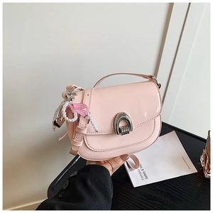 Détails du sac selle en cuir verni rose avec boucle fer à cheval et breloques perles