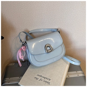 Détail du sac en cuir verni bleu clair avec boucle argentée et ruban de perles