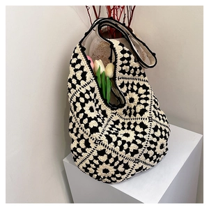 Detail shot of black and white granny square crochet pattern on large knit tote bag