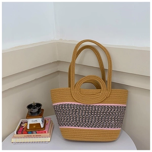Detail of hand-woven tote bag showing khaki cotton rope texture and pink diamond pattern
