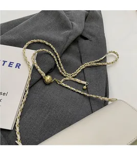 Détail du sac en cuir matelassé beige avec chaîne dorée et boucle à bille métallique réglable
