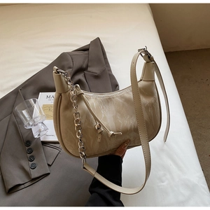Detail of cream crossbody bag featuring marble texture finish and silver metal chain strap