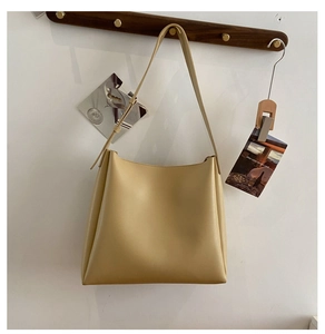 Grand sac cabas beige en PU avec large bandoulière suspendu à un crochet en bois
