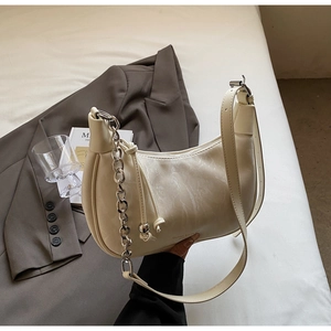 Detail of off-white hobo bag showing fine pebble grain texture and chunky silver chain