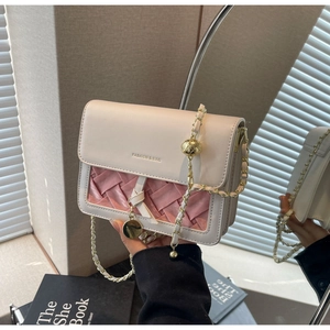 Gros plan du sac matelassé beige et rose avec détails dorés et bandoulière chaîne