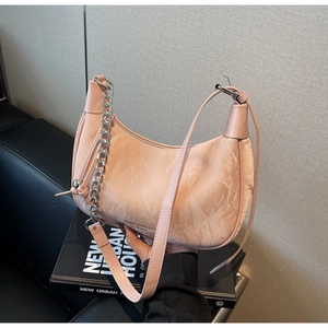 Detailed close-up of pink crescent handbag featuring marble pattern and silver chain strap