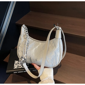 Detail of silver pleated hobo bag with metallic texture and chic chain strap