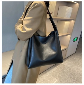 Détail d'un grand sac cabas vintage en similicuir noir porté comme sac hobo