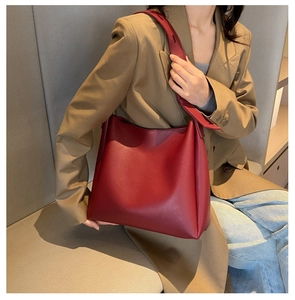 Vue détaillée du grand sac cabas bordeaux en similicuir porté par un mannequin chic