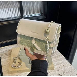 Détail du sac à bandoulière matelassé blanc et vert avec chaîne dorée et pendentif