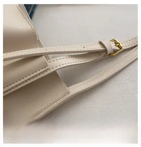 Detail of premium beige leather texture and gold buckle with precision stitching work