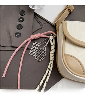 Detail geflochtener Anhänger mit Mini-Abakus und Tennisschläger an einer Handtasche