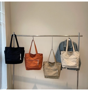Vue détaillée de sacs cabas en quatre couleurs avec poches multiples et longues bandoulières