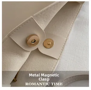 Detail of a cream tote bag featuring a high-quality round golden magnetic clasp closure
