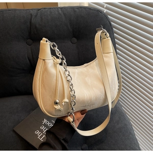 Close-up of marble texture shoulder bag with silver chain and brand logo detail