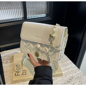 Détail du sac matelassé blanc avec chaîne dorée et charm de boule métallique
