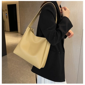 Détail d'un grand sac fourre-tout en cuir PU beige avec de larges bretelles et texture