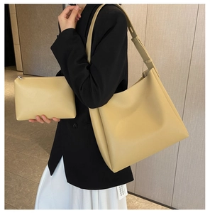 Détail de l'ensemble cabas en similicuir crème avec pochette porté par un mannequin