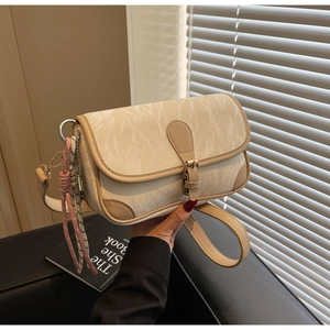 Close-up of marble texture crossbody bag with woven pendant and elegant leather trim