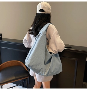 Detail of light blue crescent canvas bag showing the soft texture and spacious design