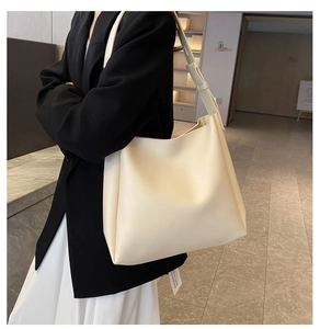 Détail du sac cabas en similicuir crème avec bandoulière réglable et étiquette papier