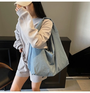 Detail of light blue slouchy canvas bag with soft nylon texture and large capacity