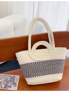 Handmade woven straw tote bag with pink stripes for beach vacations and summer travel