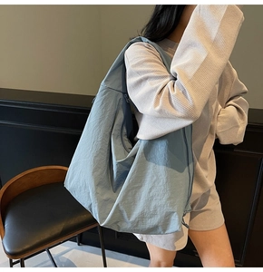 Detalle del bolso tote azul niebla al hombro mostrando su gran capacidad y textura suave