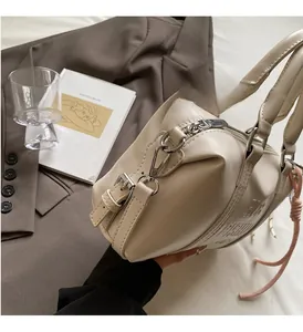 Detail of beige Boston handbag featuring shiny silver hardware and fashion embossing