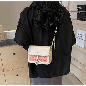 Sac bandoulière beige matelassé avec texture rose porté par un mannequin
