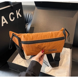Gros plan détaillé du sac bandoulière en nylon marron avec sangle noire réglable