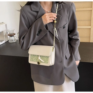 Détail de la texture en cuir tissé et du charmant nœud élégant sur ce petit sac carré chic