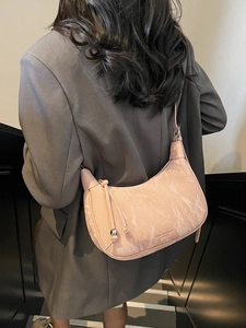 Pink marble texture crescent bag styled with a beige suit for a chic modern look