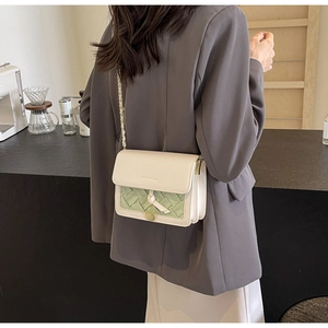 Sac bandoulière chic beige en cuir matelassé avec panneau tissé vert et chaîne dorée